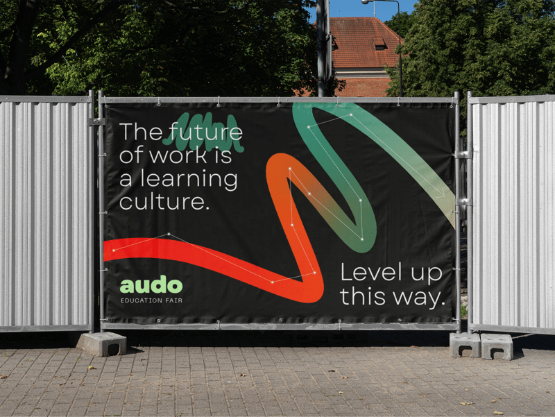 A poster on a fence showing Audo marketing materials. 