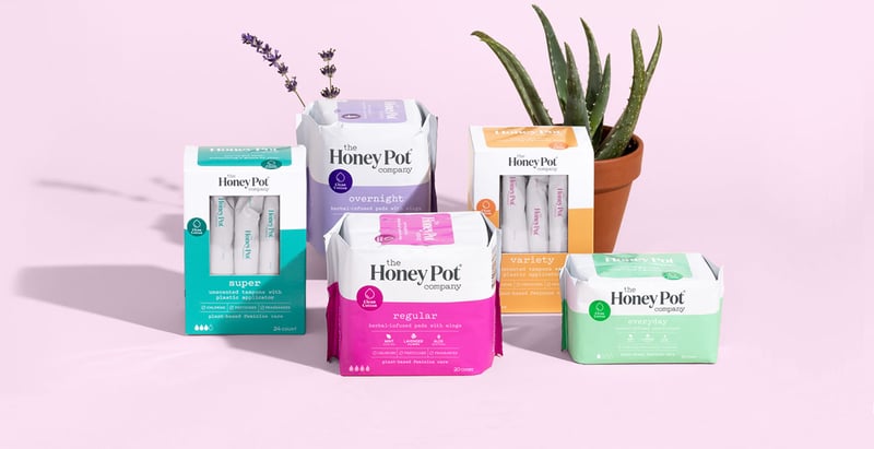 The Honey Pot - product packaging and plants against pink background